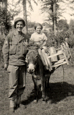 Photo of Staff Sergeant Herbert Landers of 14th Chemical Maintenance Company US Army WW-II and young French girl on a donkey taken circa the summer of 1944